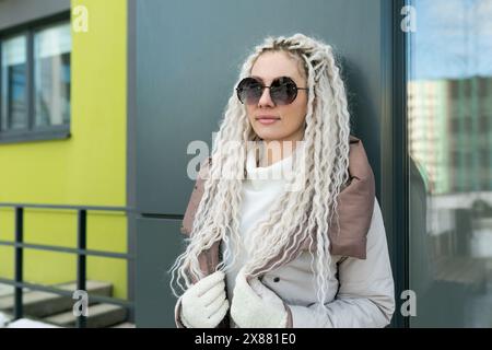 Woman With White Dreadlocks Leaning Against a Wall Stock Photo
