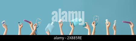 Doctor's hands with medical supplies and pills on blue background Stock Photo