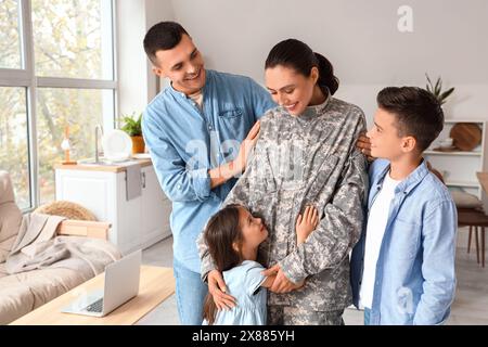 Female soldier with her husband and little children at home Stock Photo
