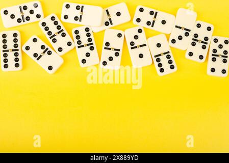 Dominoes on a yellow background. White Bones Board Game. Stock Photo