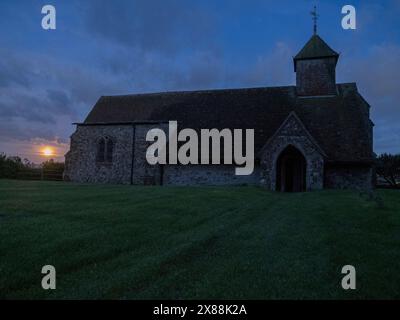 Harty, Kent, UK. 23rd May, 2024. UK Weather: the full Flower Moon seen rising next to Harty Church on the Isle of Sheppey in Kent. Credit: James Bell/Alamy Live News Stock Photo