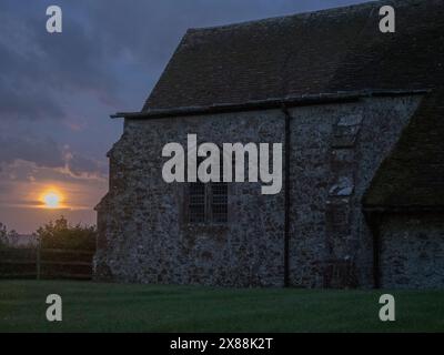 Harty, Kent, UK. 23rd May, 2024. UK Weather: the full Flower Moon seen rising next to Harty Church on the Isle of Sheppey in Kent. Credit: James Bell/Alamy Live News Stock Photo