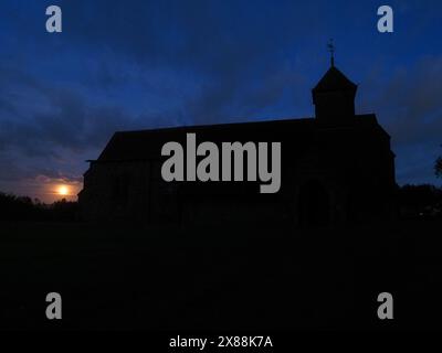 Harty, Kent, UK. 23rd May, 2024. UK Weather: the full Flower Moon seen rising next to Harty Church on the Isle of Sheppey in Kent. Credit: James Bell/Alamy Live News Stock Photo