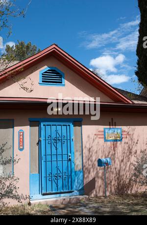 Charming painting within the Zia symbol on the front wall of a house in a historic neighborhood with blue door in downtown Las Cruces, NM Stock Photo