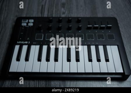 Black midi keyboard on a wooden table. Musical instrument. High quality photo Stock Photo