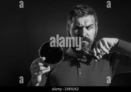 Barber scissors and mirror, barber shop. Cutting mustache and beard with barbers scissors. Facial Hair Trends. Beard Beauty Care Products. Cosmetics Stock Photo