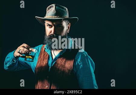 Bartender holding glass of whisky. Tasting and degustation concept. Retro vintage man with whiskey or scotch. Bartender leather apron holding whisky Stock Photo
