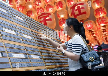 (240524) -- BEIJING, May 24, 2024 (Xinhua) -- A visitor selects creative products inspired by Chinese characters during the 20th China (Shenzhen) International Cultural Industries Fair (ICIF) at the Shenzhen World Exhibition and Convention Center, Shenzhen, south China's Guangdong Province, May 23, 2024. The 20th ICIF opened here on Thursday. According to the organizers, the five-day event held offline and online simultaneously has attracted over 6,000 government entities, cultural organizations and enterprises, with more than 120,000 exhibits on display. (Xinhua/Liang Xu) Stock Photo