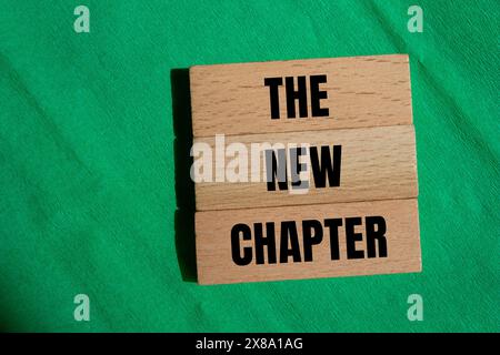 The new chapter words written on wooden blocks with green background. Conceptual the new chapter symbol. Stock Photo