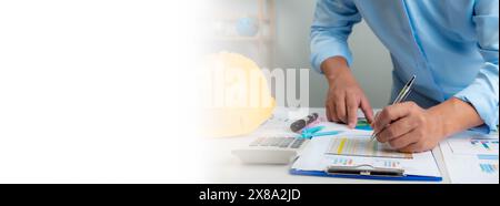 Architect or engineer sitting at desk in office, Cost calculation, Construction planning, structural calculation, Project construction cost planning a Stock Photo