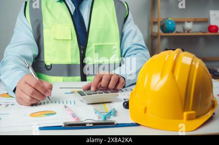 Architect or engineer sitting at desk in office, Cost calculation, Construction planning, structural calculation, Project construction cost planning a Stock Photo