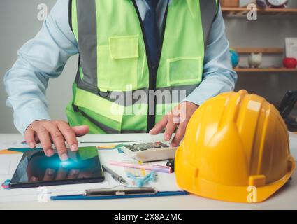 Architect or engineer using tablet to work on table, cost calculation, construction planning, structural calculation, construction cost planning, stru Stock Photo