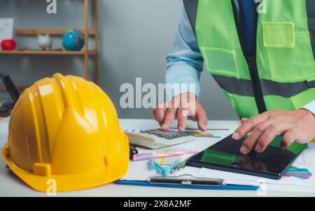 Architect or engineer using tablet to work on table, cost calculation, construction planning, structural calculation, construction cost planning, stru Stock Photo