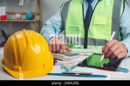 Architect or engineer using tablet to work on table, cost calculation, construction planning, structural calculation, construction cost planning, stru Stock Photo