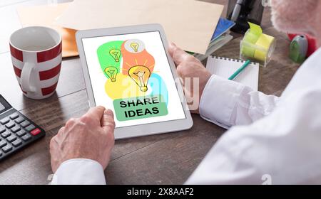 Share ideas concept shown on a tablet held by a man Stock Photo