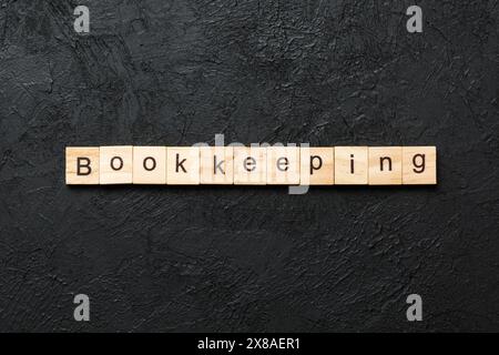bookkeeping word written on wood block. bookkeeping text on table, concept. Stock Photo