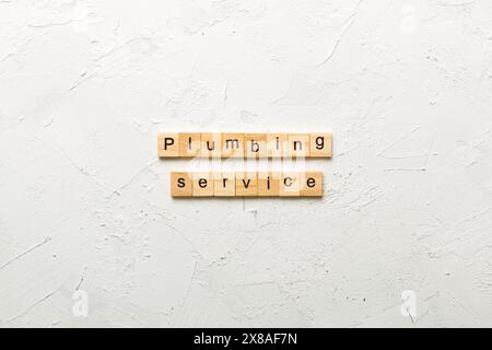 Plumbing service word written on wood block. Plumbing service text on cement table for your desing, concept. Stock Photo