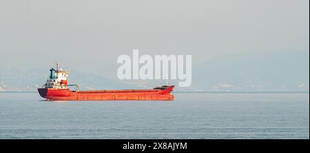 Orange general cargo ship anchored off the coast of Alanya, Antalya Stock Photo