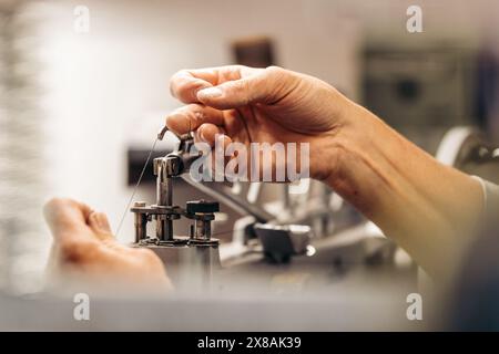 Hands working on a sewing machine in a detailed close-up Stock Photo
