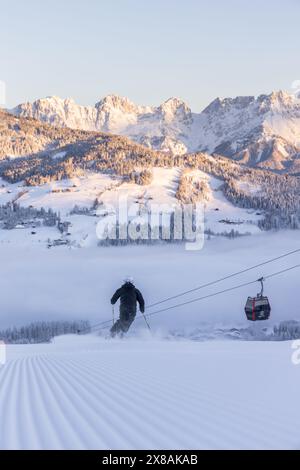 Skier on groomed slope with cable car in KitzbÃ¼hel, Tyrol, Austria Stock Photo