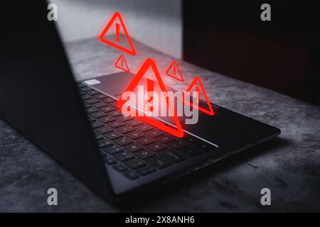 Laptop with hologram warning sign for notification error. Programmer, developer and maintenance system concept. Scam virus attack. Stock Photo