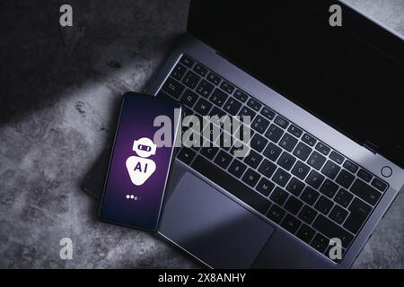 Smartphone laying on laptop displaying virtual chat with AI. Artificial Intelligence concept. Command prompt to generate something. Stock Photo