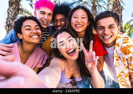 Multiethnic group of young happy friends hanging out in the city - Multiracial group of students meeting and having fun outdoors, concepts about youth Stock Photo
