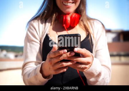 Unrecognizable caucasian woman using an app on her smartphone outdoors. Stock Photo