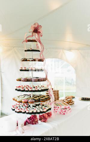 Iced donut and strawberry cupcake tower at dessert table Stock Photo