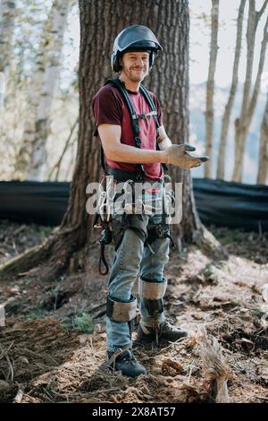 Portrait of logger wearing helmet and climbing harness Stock Photo