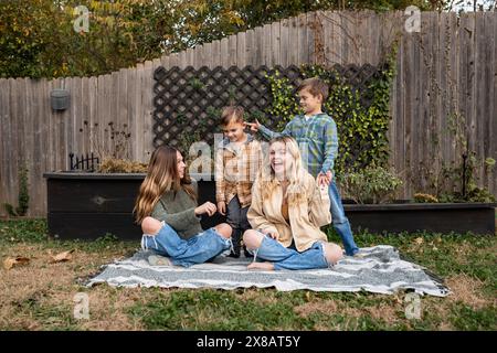 Happy siblings enjoying a  playful moment in backyard on an autumn day Stock Photo