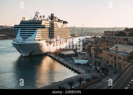 The MSC Seaview, a large cruise ship, docked at the Port of Valletta, Malta, as the sun sets over the city Stock Photo