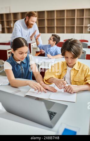 kids are sitting closely together at a table, engrossed in a discussion, their expressions reflecting deep engagement. Stock Photo