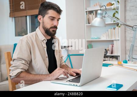 Business man working on laptop at home office. Young student using computer remote studying Stock Photo