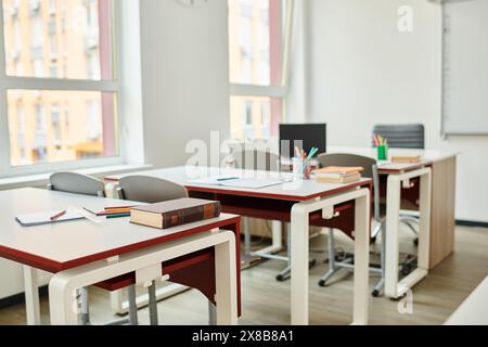 The classroom sits empty, desks and chairs aligned in neat rows Stock Photo