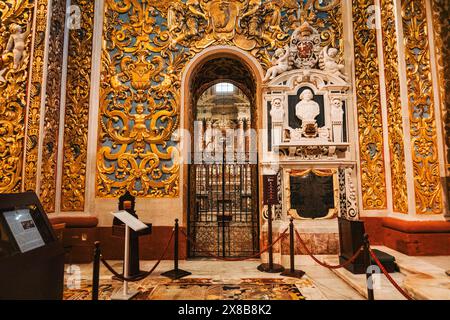 Inside St. John's Co-Cathedral in Valletta, Malta: golden details on the walls, ornate entrance to the chapel Stock Photo