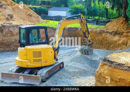 It is job of an excavator to fill irregularities in excavations with granite rubble base before laying concrete foundations Stock Photo