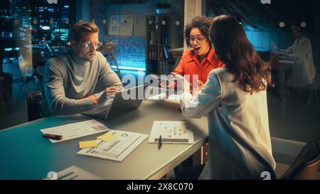 Group of Managers Having a Team Meeting Long After Work Hours in the Evening. Colleagues Discussing Annual Financial and Marketing Reports. Teamwork in Creative Office. Close Up on Hands. Stock Photo