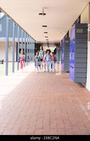 In school, a diverse group of students is walking down the hallway with copy space outdoors Stock Photo