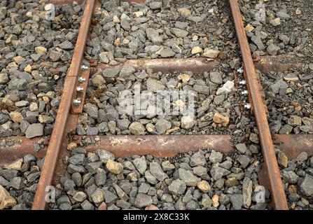 connecting two old and rusty railway sections with new bolts and nuts, rehabilitated for tourism Stock Photo