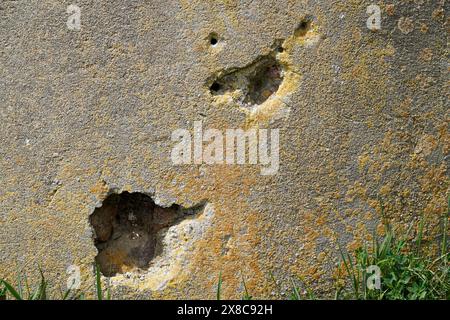 Rough old concrete wall texture with bullet wholes and scratches Stock Photo