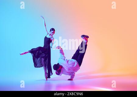 Classical ballerina and a contemporary street dancer making breathtaking creative performance, dancing against gradient background in neon light Stock Photo