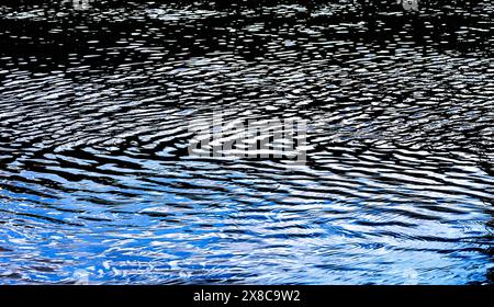 Foam and reflected light creating abstract designs on surface of flowing river - Preuilly-sur-Claise, Indre-et-Loire (37), France. Stock Photo