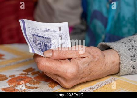 Elderly woman clutches a 50 Danish kroner banknote in her hand, Concept, Denmark finances of elderly people, close up Stock Photo