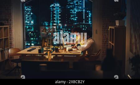 Two Creative Multicultural Colleagues Collaborate on a Project and Work Together as a Team. Marketing Manager and Designer Talking and Discussing Changes to an Advertising Campaign. Evening at Work. Stock Photo