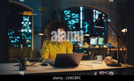 Expressive Multiethnic Middle Eastern Female Working on a Creative Job Position in an Advertising Company. Manager Brainstorming Ideas, Excited for the Selection of her Project. Office at Night. Stock Photo
