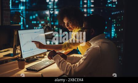 Small Creative Multicultural Team Collaborate on a Project and Work Together as a Team. Project Manager and Software Developer Talking and Discussing Changes to Document. Evening at Work. Stock Photo