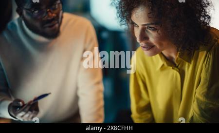 Multicultural Creative Colleagues Discussing a New Business Opportunity, Talking in an Office Meeting Room, Using Laptop Computer. Close Up on Faces of Team Members. Stock Photo