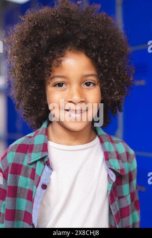 In school, young biracial boy is standing, smiling Stock Photo