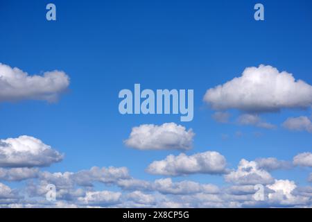 small soft cumulus fair weather clouds in a blue sky Stock Photo